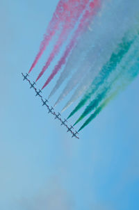 Low angle view of airshow against blue sky