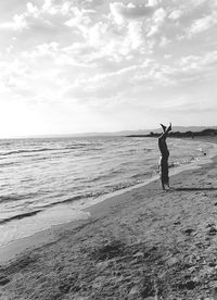 Full length of woman walking on beach against sky