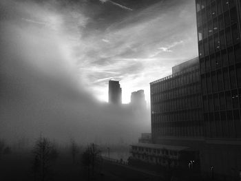 Low angle view of modern buildings against cloudy sky