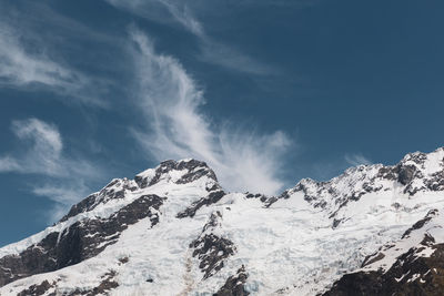 Low angle view of snowcapped mountains against sky