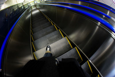 Low section of man standing on escalator