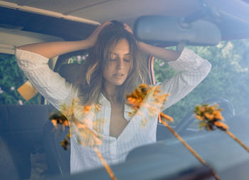 Through windshield of charming female driver sitting in automobile