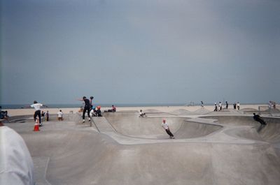 People skateboarding at park against clear sky