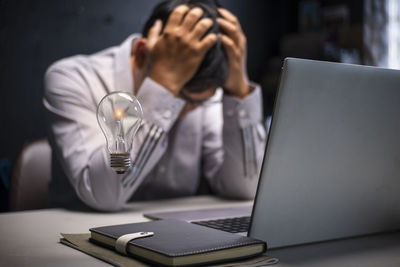 Midsection of man using laptop at table
