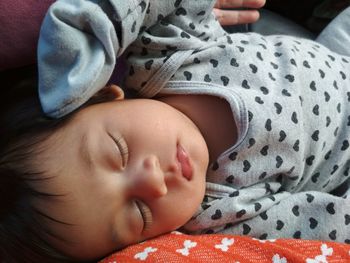 Close-up of baby sleeping in bed