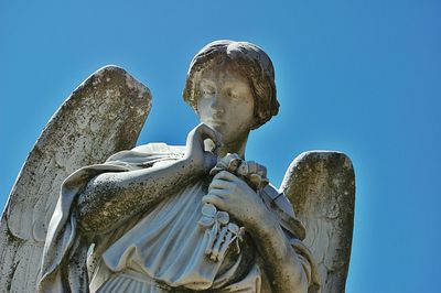 Low angle view of statue against clear blue sky