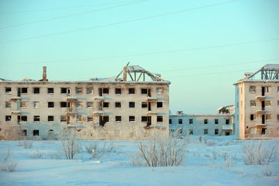 View of buildings against clear blue sky during winter