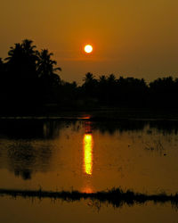 Scenic view of lake against orange sky