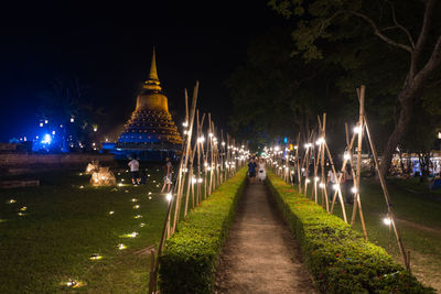 Illuminated temple amidst buildings at night