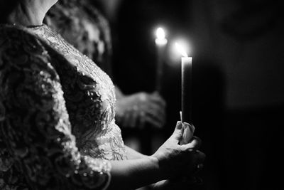 Close-up of woman holding burning candle