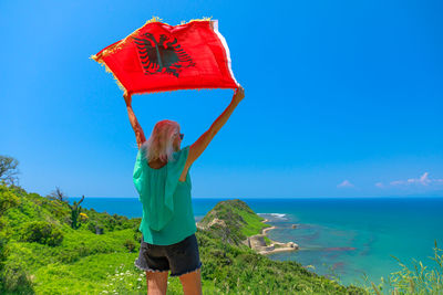 Rear view of woman standing against sea