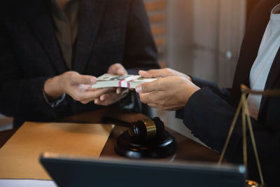 Midsection of lawyer working on table