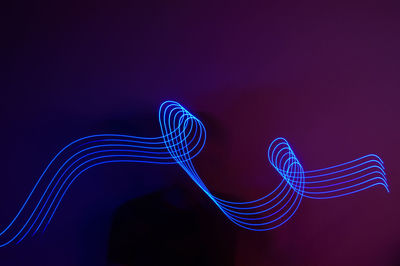 Close-up of illuminated light painting against black background