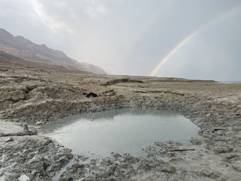 Scenic view of rainbow over mountain against sky