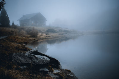 Scenic view of lake by buildings against sky