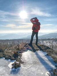 Full length of woman standing on snow covered mountain against sky