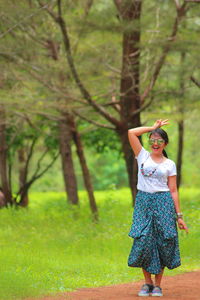 Woman standing on tree trunk in forest