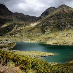 Scenic view of lake by mountain against sky