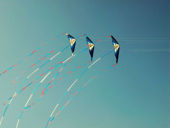 Low angle view of multi colored hanging against clear blue sky