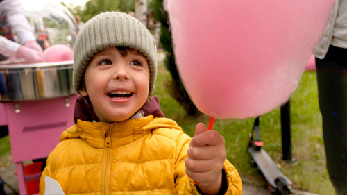 Boy eating candy floss in park