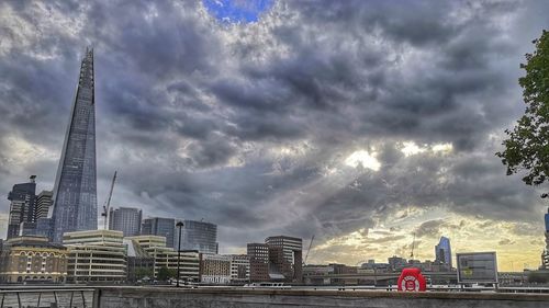 Buildings in city against cloudy sky