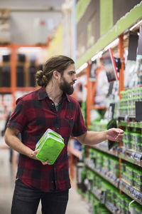 Male customer buying nail boxes in hardware store