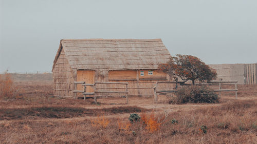 House on field against clear sky