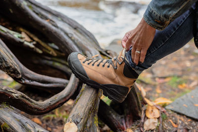 Low section of person wearing shoes on wood