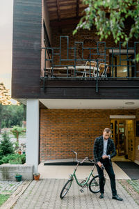Man with bicycle on building in city