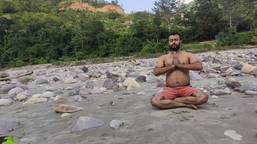 Young man sitting on rock