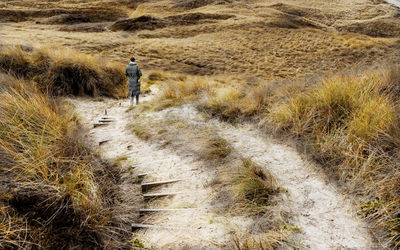 Rear view of man standing on footpath