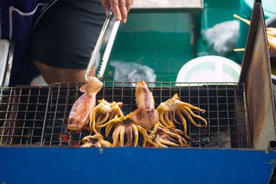 Close-up of man preparing food on barbecue grill