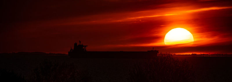 Scenic view of sea against orange sky