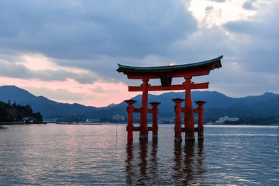 Floating torii gates shrine on sea at sunset