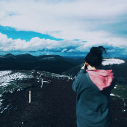 Rear view of woman looking at mountains during winter