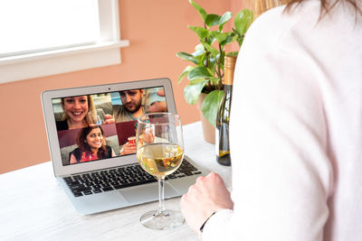 Midsection of woman using laptop on table