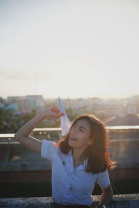 Portrait of beautiful woman standing against sky