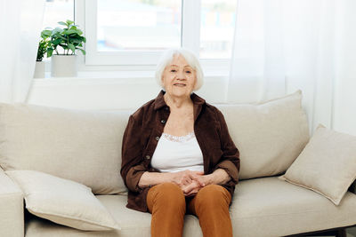 Young woman sitting on sofa at home