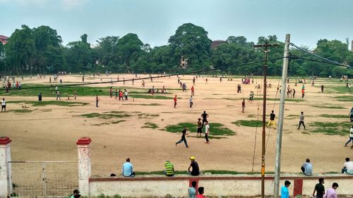 People playing on field against sky