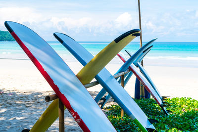 Deck chairs on beach against sky