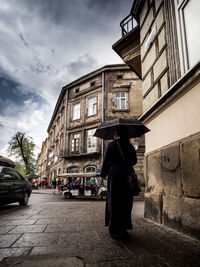 Man walking on street against buildings in city