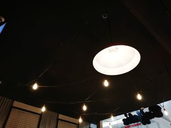 Low angle view of illuminated pendant light hanging from ceiling