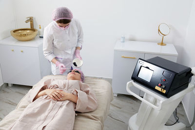 Portrait of female doctor examining patient in hospital