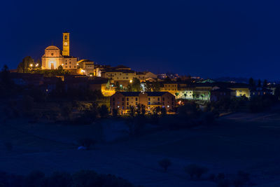 Illuminated buildings against sky at night