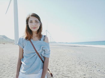 Portrait of young woman standing at beach