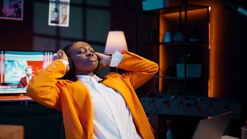 Side view of young woman using mobile phone in office