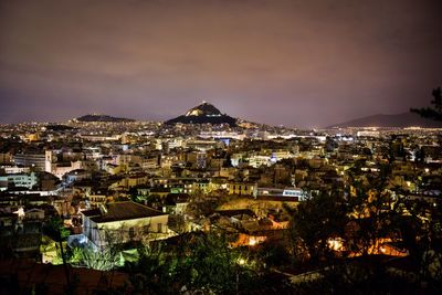 Illuminated cityscape against sky at night