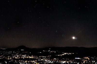 Illuminated cityscape against sky at night
