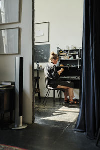 Jeweller sitting on chair working in workshop