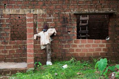 Scarecrow against brick wall